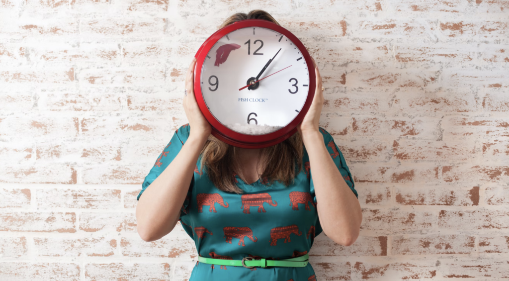 Go Red for Dyslexia: Dyslexia Awareness Through the Ages 9 woman in a patterned dress holding up a red clock in front of her face